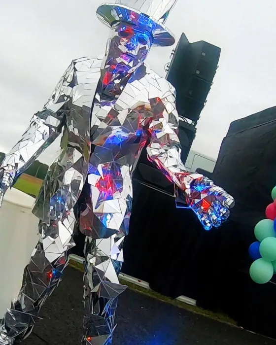 Silver mirror man on stilts entertaining guests at an outdoor event