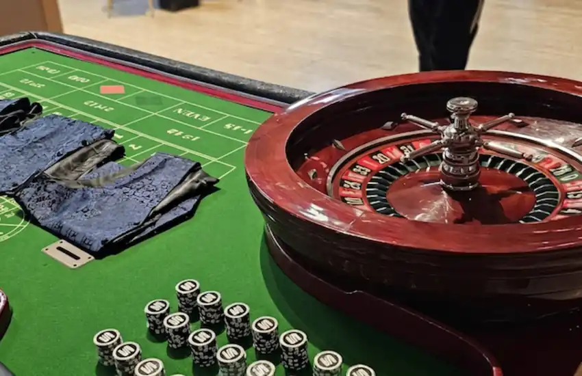 Detalle de una mesa de ruleta francesa con rueda de madera, tapete de apuestas verde y fichas de casino preparadas para una actividad de entretenimiento en eventos corporativos y fiestas temáticas.
