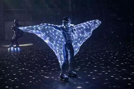 Bailarina en patines LED con alas luminosas en show futurista para eventos corporativos