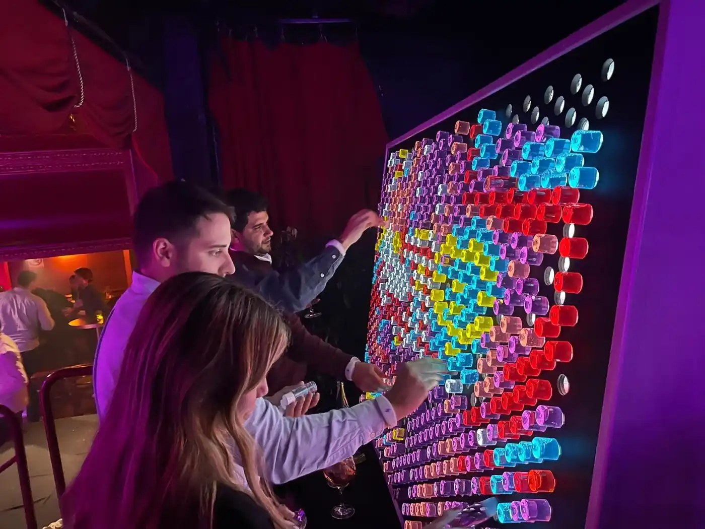 Assistents creant un disseny en un panell lluminós en un congrés