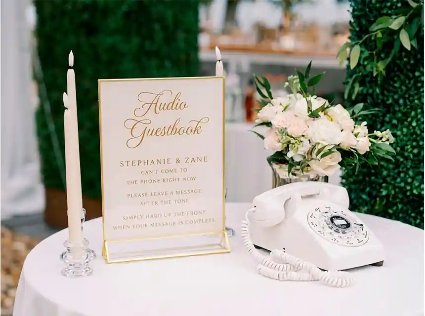 Convidada escoltant un missatge en un telèfon retro en un casament
