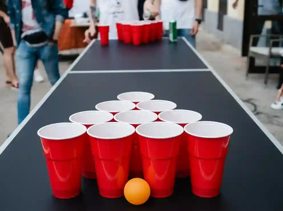 Taula de beer pong en un casament amb convidats jugant