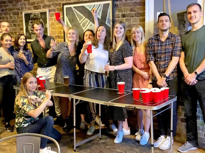 Companys jugant a beer pong en un sopar de Nadal