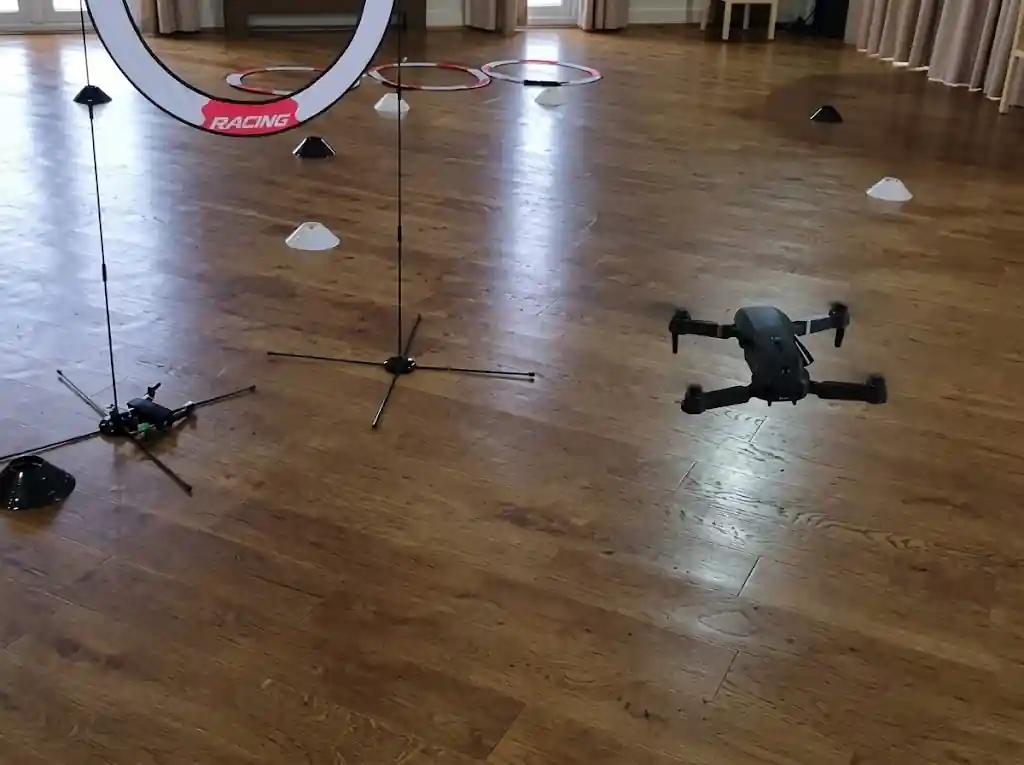 Treballadors pilotant drons en un circuit durant una festa d'empresa
