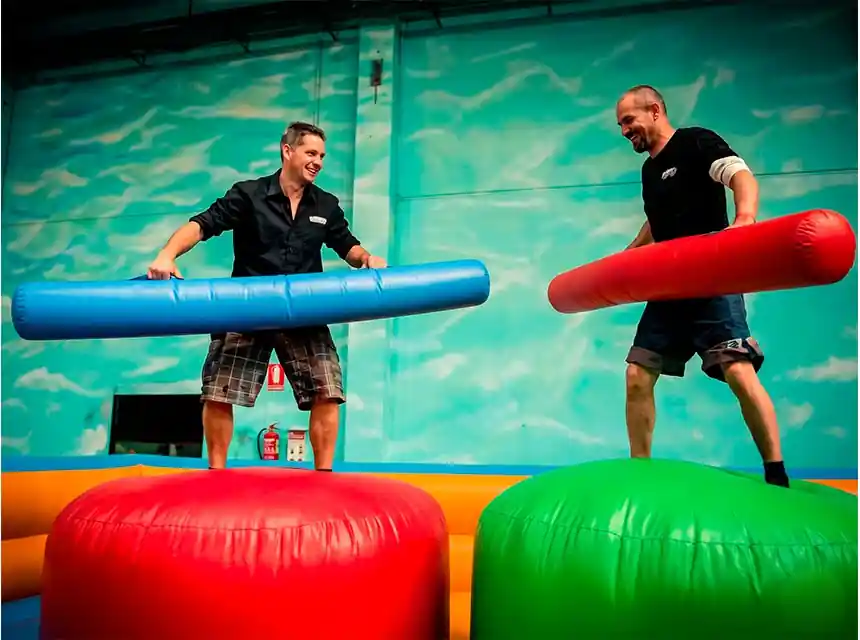 Two adults duelling on a gladiator inflatable