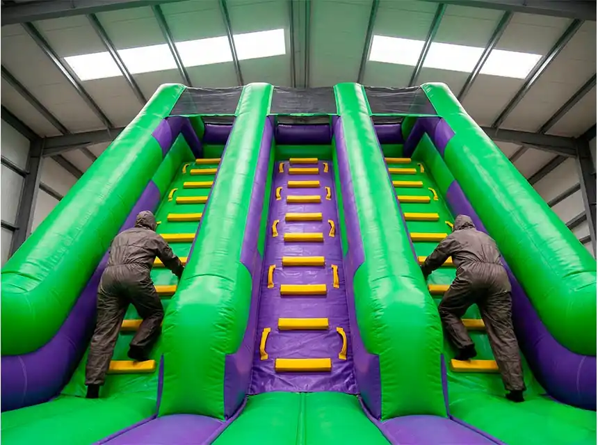 Participant pujant una escala infernal inflable en un esdeveniment