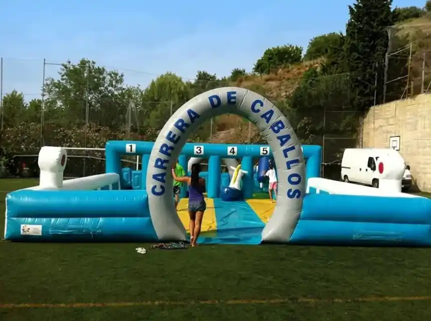 Amics competint a l'hipòdrom inflable d'un comiat de solter