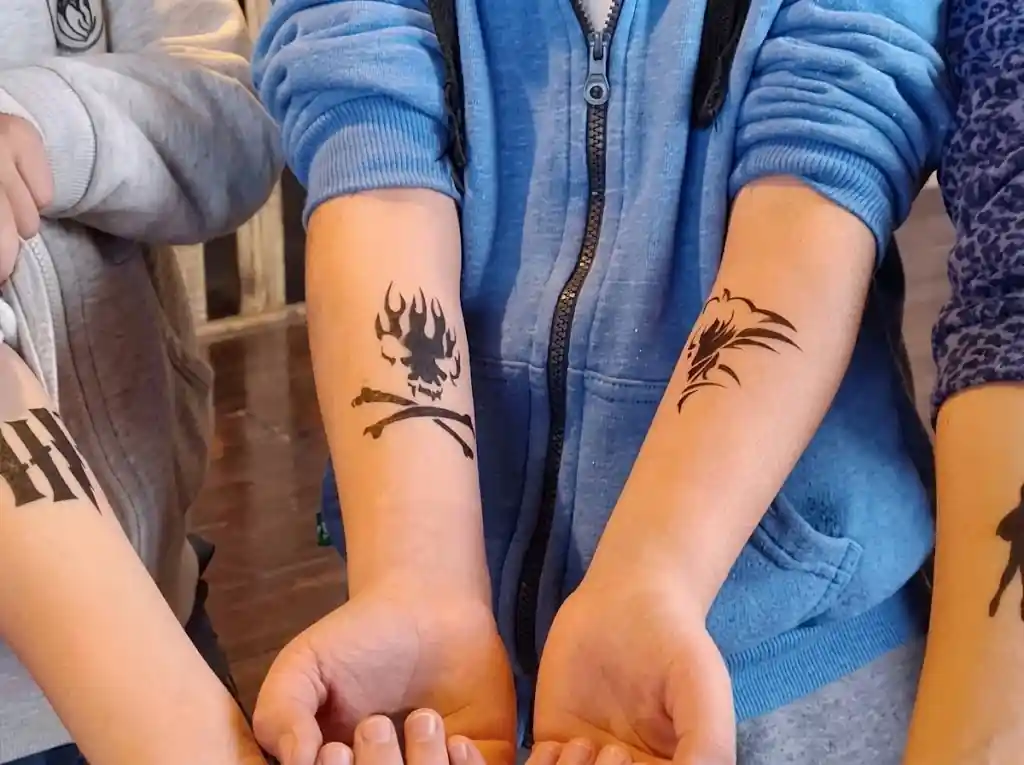 Artist applying airbrush tattoos at a festival