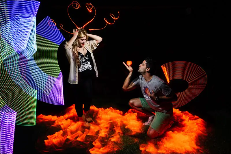 Artista creant light painting a l'estand d'una fira