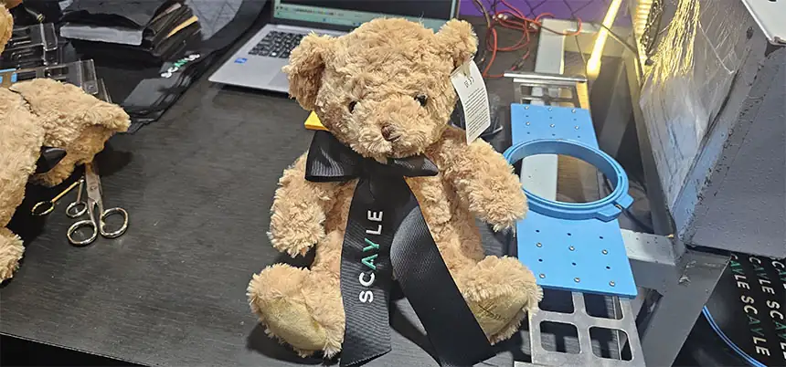 Teddy bear with embroidered ribbon at a trade fair stand