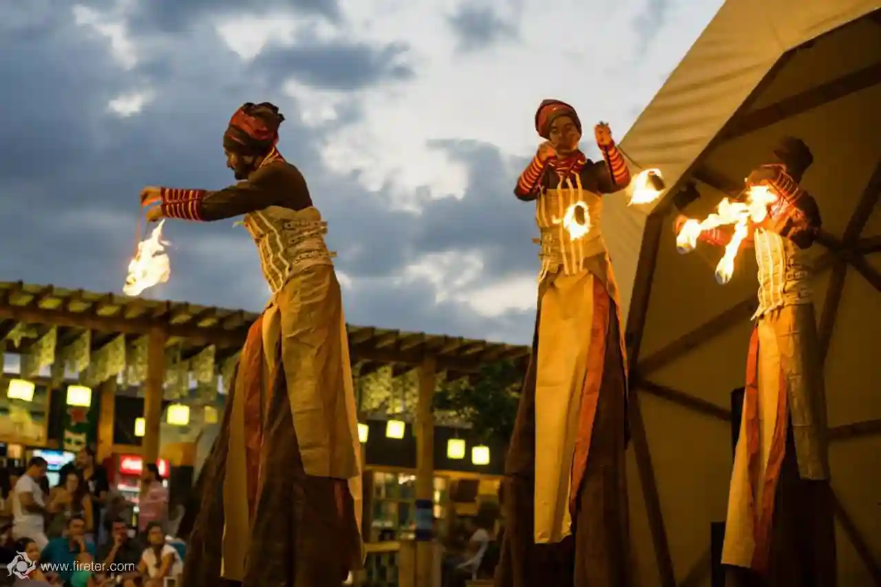 Stilt performer with fire fans at a corporate gala
