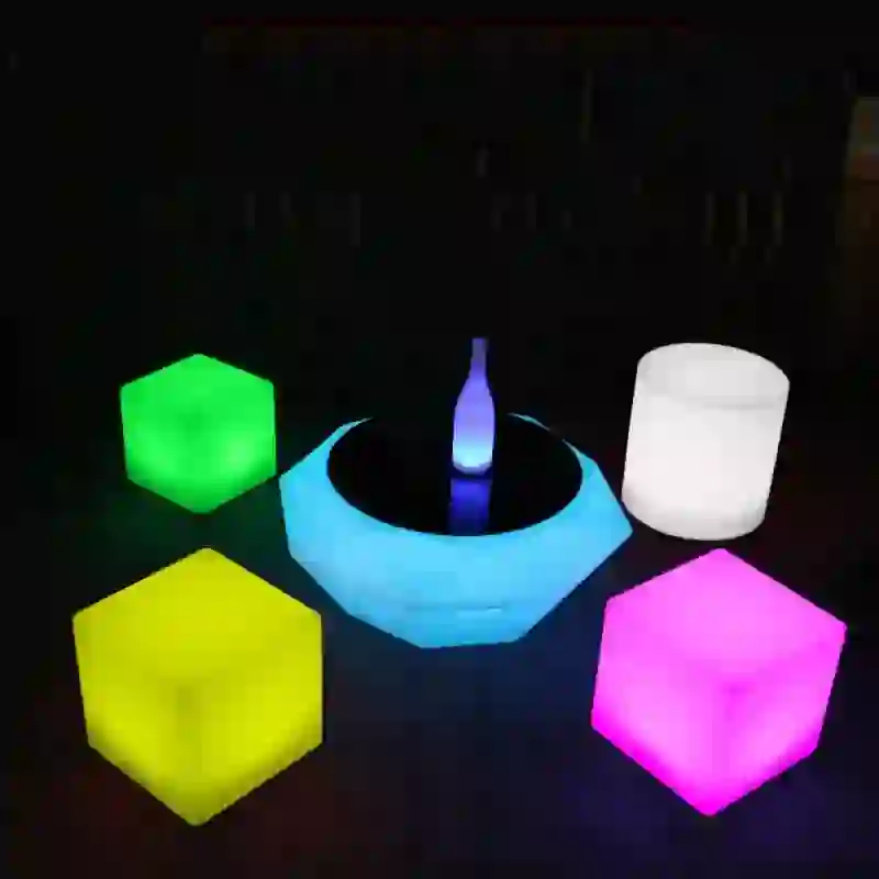 Zona chill out amb taules LED il·luminades en un acte nocturn