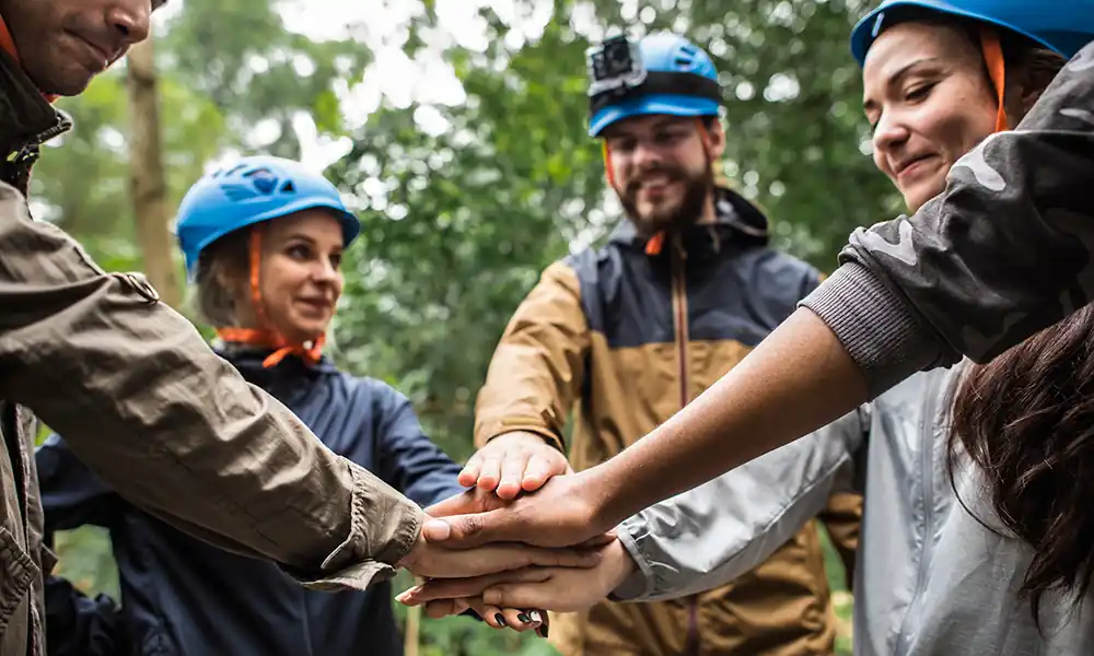 Equip d'empresa construint un refugi en un team building de supervivència