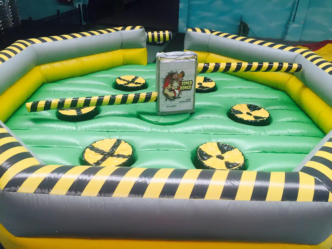 Adults jumping the bar of an inflatable sweeper at an event