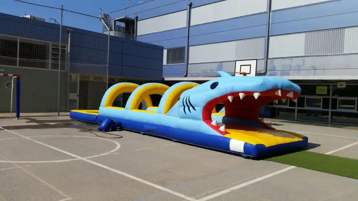 Nens entrant per la boca de l'inflable aquàtic Tauró