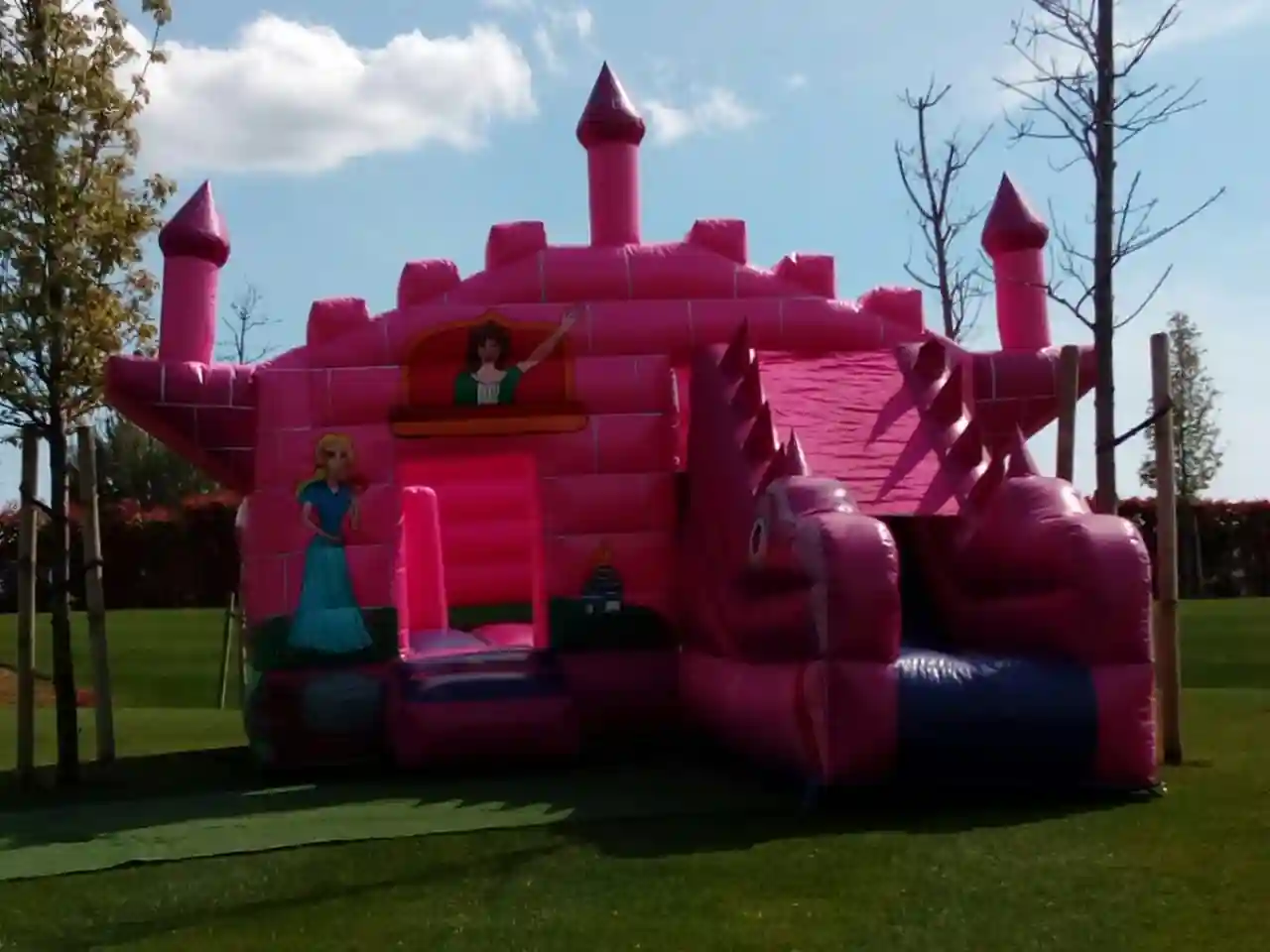 Nenes jugant al castell inflable rosa en un bateig