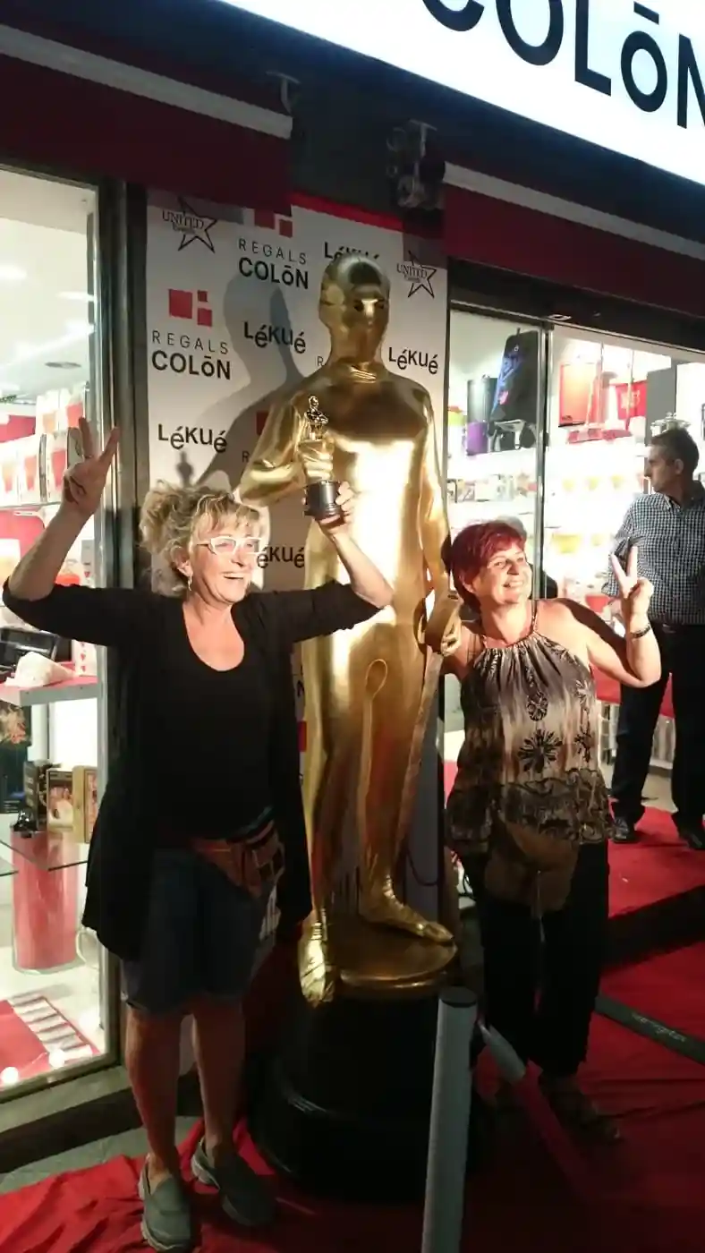 Treballadors posant amb estatueta en una gala de premis estil Oscar
