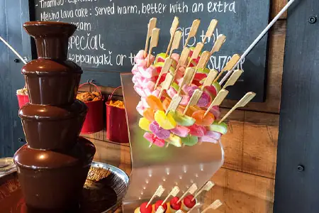 Convidats sucant maduixes en una font de xocolata en un acte corporatiu