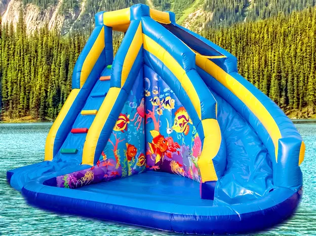 Infants lliscant en un inflable d'aigua en un casal d'estiu