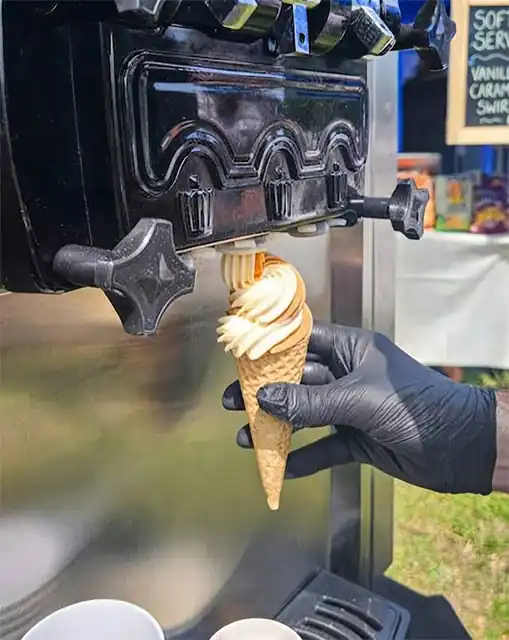 Màquina de gelats soft servint cucurutxos en un estand de fira