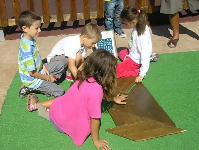 Children building shapes with a giant tangram at a science fair