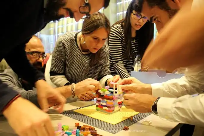 Participants d'una convenció resolent un repte de team building LEGO
