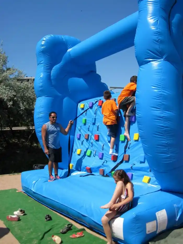 Nens baixant pel tobogan inflable en un pavelló