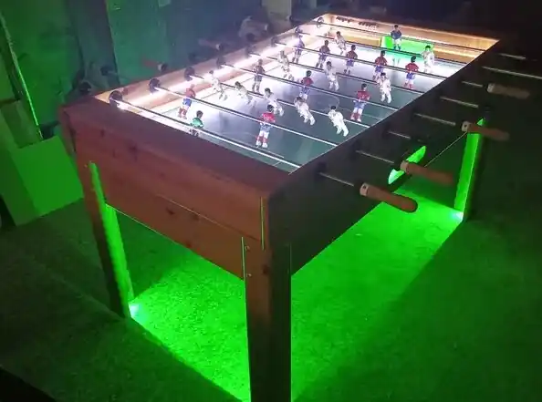 Convidats jugant al futbolí lluminós en una discoteca