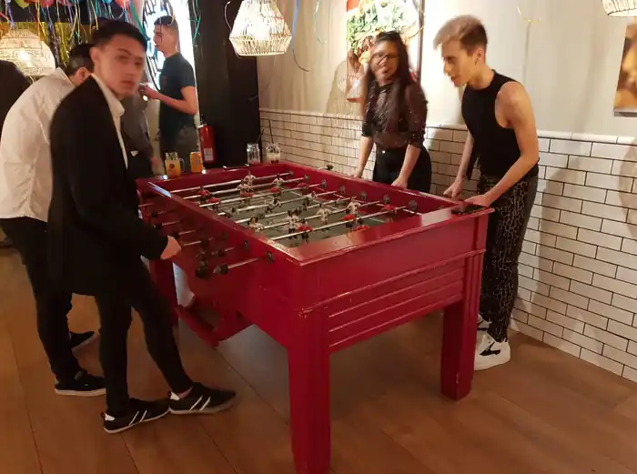 Futbolín valenciano rojo para eventos con invitados jugando una partida