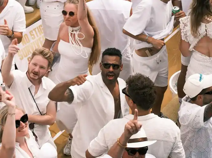 Invitados vestidos de blanco bailando en un evento temático Ibiza White Party