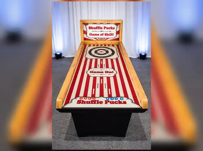 Mesa de Shuffle Puck de feria con la diana de puntuación al fondo